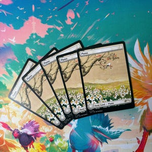 May include: Four "Plains" Magic: The Gathering trading cards with a landscape illustration of a tree and field of white flowers. The cards are on a colorful playmat with birds and fantasy creatures.