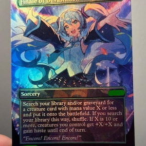 May include: A holographic trading card titled Finale of Devastation featuring an anime-style character with long teal hair and a blue outfit. The card displays sorcery text, mana symbols, and the flavour text Encore! Encore! Encore! in a vibrant, colourful design.