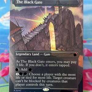 Op de afbeelding: Een rechthoekige ruilkaart getiteld The Black Gate, met een donker, grillig stenen fort met een gloeiende gele boog. De kaarttekst beschrijft een Legendary Land - Gate met spelmechanieken, waaronder een kostprijs van 3 levenspunten.