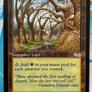 May include: A Magic: The Gathering card titled "Gaea's Cradle." The card features a fantasy landscape with stylized trees and a forest scene. Text includes game instructions and flavor text. The card is a Legendary Land.