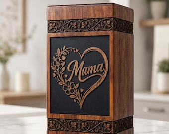 Könnte beinhalten: Eine Holzkiste mit dunkler Holzoberfläche und einer schwarzen Mittelplatte. Die Platte hat ein herzförmiges Blumendesign mit dem Wort "Mama" in der Mitte geschnitzt. Die Box hat dekorative Schnitzereien oben und unten.