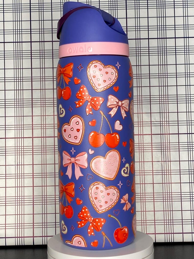 A colorful, patterned water bottle with various heart and bow designs on it.