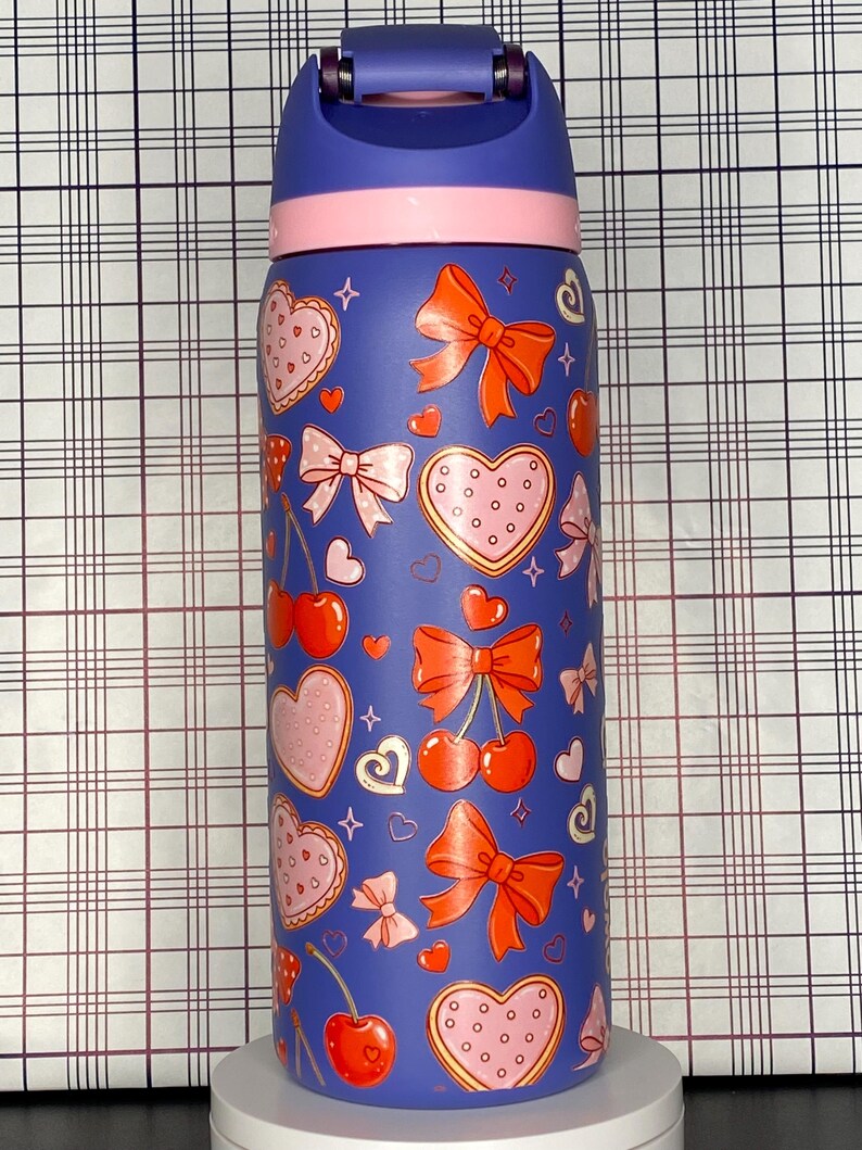A colorful, patterned water bottle with various heart and bow designs on it.