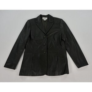 May include: A black leather blazer featuring a notched lapel, long sleeves, and a three-button front closure. The garment includes vertical seam detailing on the front panels and a Pendleton brand label located at the interior neckline.