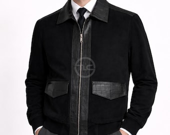 May include: Black jacket with leather detailing on the collar, zip panel, and pockets. The jacket features a zip-up front and two front pockets. The model is wearing a white shirt and a black tie. The jacket is made of a soft, suede-like material.