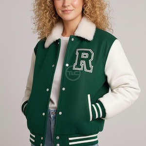 May include: Green and white varsity jacket with a white faux fur collar. The jacket features a large white letter "R" on the chest and white sleeves. The jacket has white stripes on the cuffs and hem.