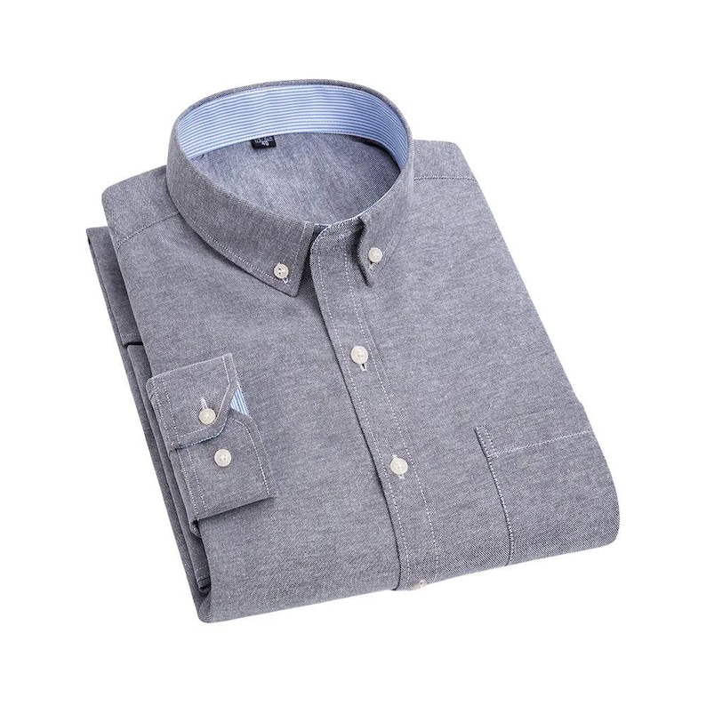 A grey button-down shirt with a classic collar and a chest pocket. The shirt has long sleeves with buttoned cuffs and white buttons. The collar has a striped pattern. The shirt is neatly folded.