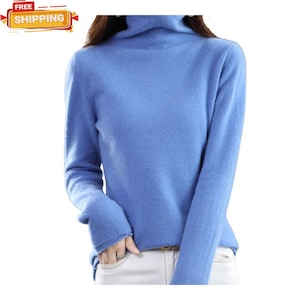 May include: A light blue turtleneck sweater. The long-sleeved sweater is made of a soft material and has a high, folded collar. The sweater is a solid color and is a close-up shot.
