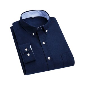 A navy blue button-down shirt with a classic collar and buttoned cuffs. The shirt features white buttons and a pocket on the left side. The collar has a striped pattern on the inside.