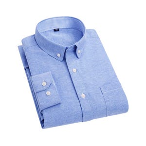 A pale blue button-down shirt with a classic collar and a chest pocket. The shirt has long sleeves with buttoned cuffs and white buttons. The collar has a striped pattern. The shirt is neatly folded.