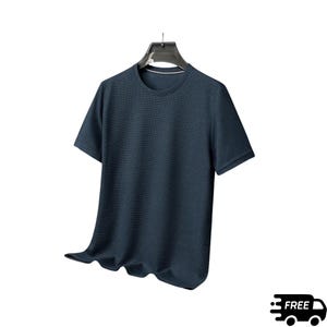 May include: A short-sleeved, navy blue t-shirt hangs from a black hanger. The shirt has a textured knit pattern and a crew neck with a white trim. The fabric drapes softly, suggesting a comfortable fit. The overall style is casual and versatile.