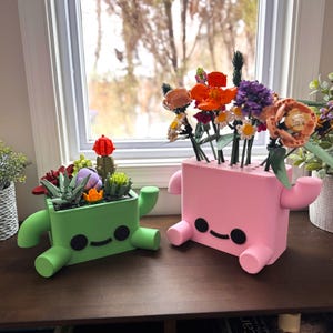 May include: A set of three ceramic mugs with a speckled, matte finish. Each mug features a different color: light blue, cream, and gray. The mugs have a simple, modern design with a rounded shape and a handle.