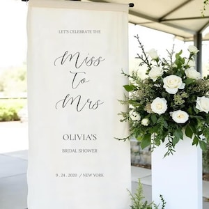 a banner that reads "Let's celebrate the Miss to Mrs. Olivia's Bridal shower 9. 24. 2020 / NEW YORK" with a floral arrangement to the right.