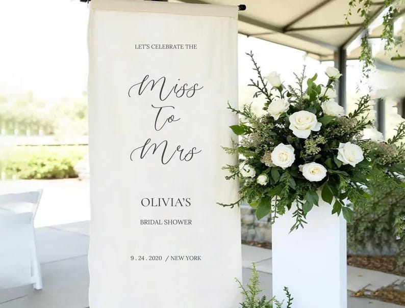 a banner that reads "Let's celebrate the Miss to Mrs. Olivia's Bridal shower 9. 24. 2020 / NEW YORK" with a floral arrangement to the right.