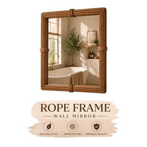 Op de afbeelding: Een rechthoekige wandspiegel met een touwframe. De spiegel reflecteert een badkamerscène met een bad, raam en decoratieve elementen. Het frame is gemaakt van dik, gedraaid touw, wat het een natuurlijke, nautische uitstraling geeft. De tekst "ROPE FRAME WALL MIRROR" staat onderaan.