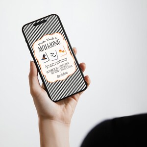 May include: A smartphone displaying a digital Halloween-themed Mahjong invitation with a black and white vertical striped background. The invitation features the text Tricks, Treats & MAHJONG, icons of a witch hat, bats, and candy corn, with event details.