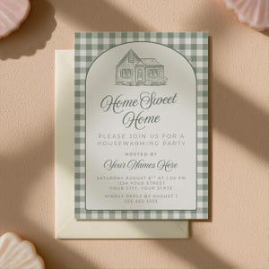 Puede incluir: Invitación a una fiesta de inauguración con un borde de patrón de cuadros vichy verde y blanco. La invitación presenta el texto "Home Sweet Home" y los detalles del evento, incluyendo la fecha, hora y lugar. Se incluye un sobre.