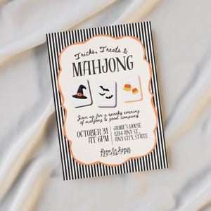 May include: A rectangular invitation card with a black and white vertical striped border and a cream-colored center featuring an orange scalloped frame. The text reads Tricks, Treats & MAHJONG, with illustrations of a witch hat, bats, and candy corn.