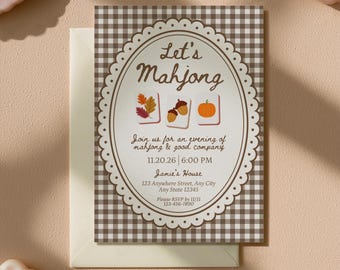 May include: A rectangular invitation card with a brown and white gingham border and a central oval frame. The text reads Let's Mahjong, Join us for an evening of mahjong & good company, 11.20.26, 6:00 PM, Jamie's House, 123 Anywhere Street, Any City, Any State 12345, Please RSVP by 11/11, 123-456-7890. Three mahjong tiles feature autumn leaves, acorns, and a pumpkin.
