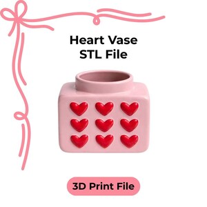 Könnte beinhalten: Eine rosa, quadratische Vase mit neun roten Herzverzierungen. Die Vase hat eine zylindrische Öffnung. Der Text "Heart Vase STL File" und "3D Print File" ist auf dem Bild zu sehen.
