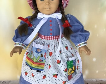 May include: A doll wearing a blue dress with a white and red gingham apron, a white bonnet with red and white gingham trim, and red bows in her hair.