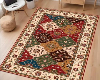 May include: A rectangular area rug with a patchwork design. The rug features a cream-colored border with floral patterns and a central field of colorful, geometric shapes in red, green, blue, and brown. The rug is placed on a wooden floor.