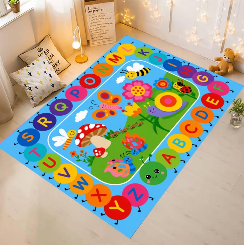 Pode incluir: Um tapete infantil colorido com fundo azul e design l&uacute;dico. O tapete apresenta uma borda alfab&eacute;tica e uma cena central com insetos de desenho animado, flores e um cogumelo. As letras s&atilde;o de v&aacute;rias cores.