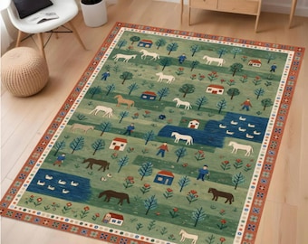 May include: Rectangular rug depicting a rural landscape. The design includes white and brown horses, blue houses, trees, and figures on a green field. The border has a geometric pattern in red, blue, and white.