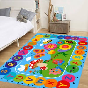 Pode incluir: Um tapete infantil colorido com fundo azul e borda de letras do alfabeto. O tapete apresenta ilustra&ccedil;&otilde;es de desenhos animados de insetos, flores e um cogumelo. O tapete &eacute; retangular e foi projetado para um quarto infantil.