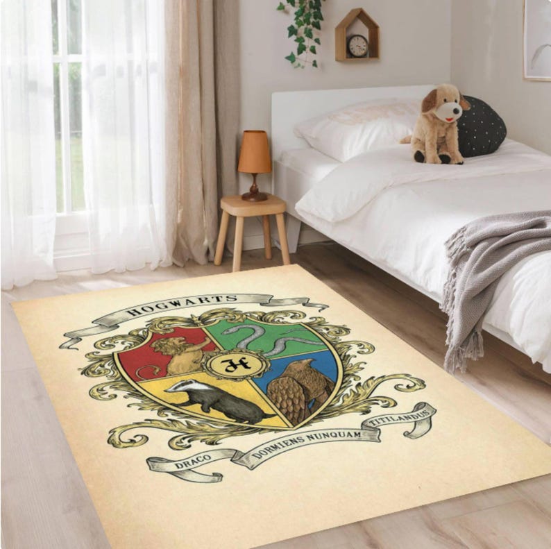 May include: A rectangular beige rug featuring the Hogwarts crest. The crest is a shield divided into four sections, each with a different animal and color. The rug has the words "HOGWARTS" and "DORMENS NUNQUAM TITILLANDUS" on it.