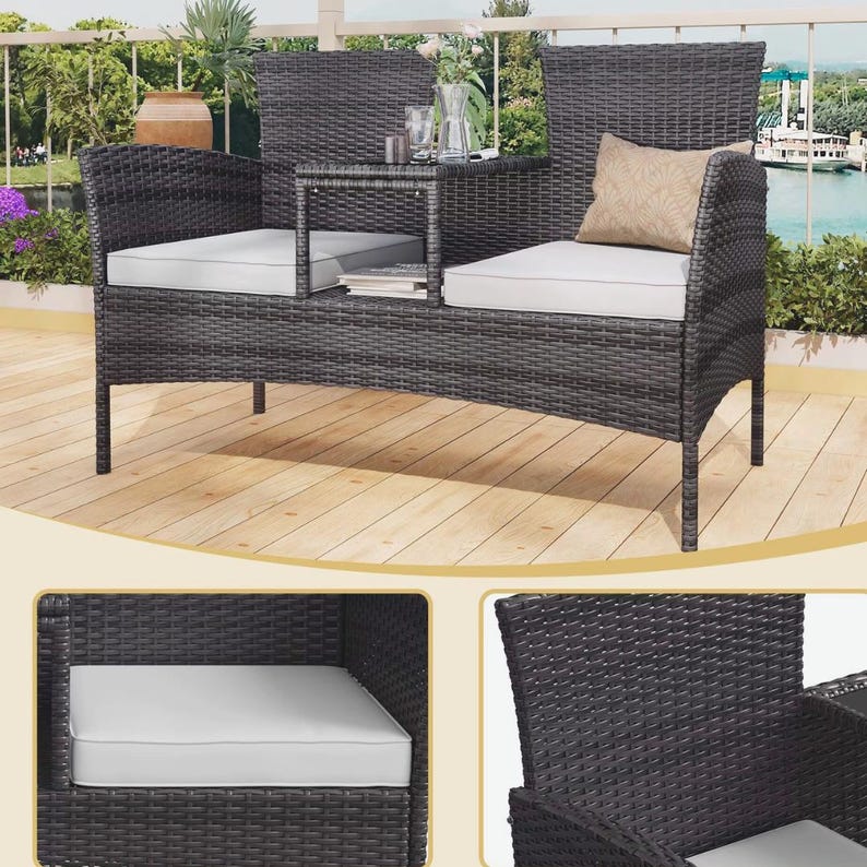 Puede incluir: Sof&aacute; de exterior de mimbre gris oscuro con una mesa auxiliar incorporada. El sof&aacute; tiene dos asientos con cojines blancos y un peque&ntilde;o coj&iacute;n beige. La mesa auxiliar est&aacute; entre los asientos. El sof&aacute; est&aacute; sobre una terraza de madera.