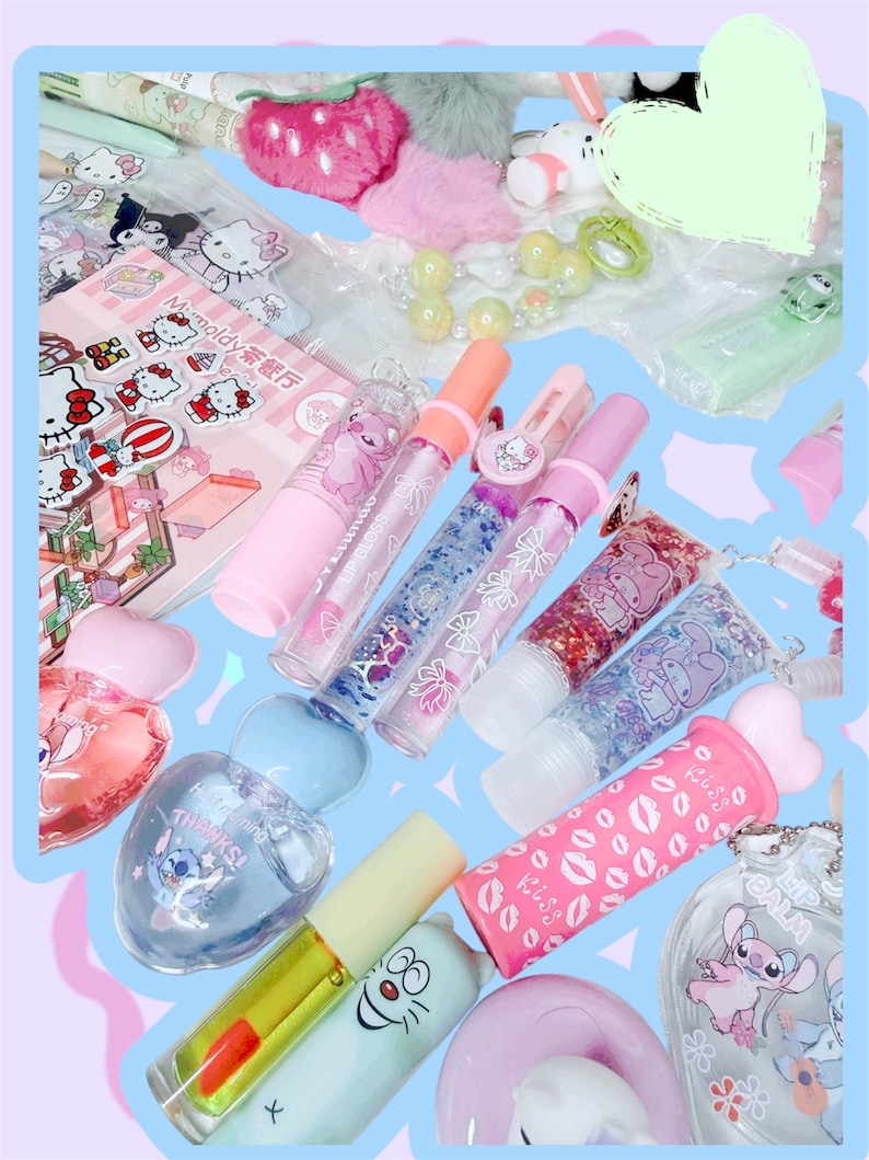 Op de afbeelding: Een verzameling kleurrijke lipgloss, parfums en accessoires. De afbeelding toont verschillende tinten roze, blauwe en transparante lipgloss tubes met glitter en karakterontwerpen. Andere items zijn een parfumfles, een notitieblok en sleutelhangers.