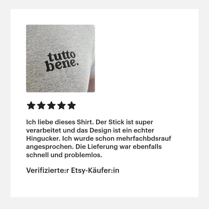 May include: A heather gray t-shirt featuring the black embroidered text "tutto bene." on the chest. The embroidery is positioned on the upper left side of the garment, showcasing a clean, bold, and lowercase serif typeface design.