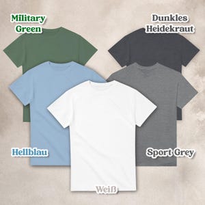 May include: A collection of five short-sleeved crew neck t-shirts in various solid colors including military green, dark heather, light blue, white, and sport grey, each labeled with its respective color name in a white outlined font.