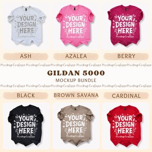 K&ouml;nnte beinhalten: Ein Mockup-Bundle von Gildan 5000 T-Shirts in verschiedenen Farben, darunter Ash, Azalea, Berry, Schwarz, Brown Savana und Cardinal. Jedes Shirt zeigt den Text "YOUR DESIGN HERE" in wei&szlig;er, dekorativer Schrift.