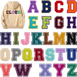 May include: A beige hooded sweatshirt with the word CLOUD in multicolored varsity-style letters on the back, accompanied by a complete set of individual alphabet patches in various colors, textures, and collegiate block letter designs.