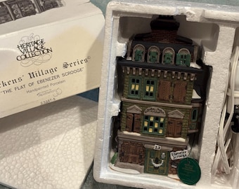 Può includere: Un edificio in miniatura in porcellana dipinta a mano della "Dickens' Village Series". L'edificio a tre piani ha un tetto scuro, persiane verdi e una porta con il numero 13. La scatola recita "The Flat of Ebenezer Scrooge."