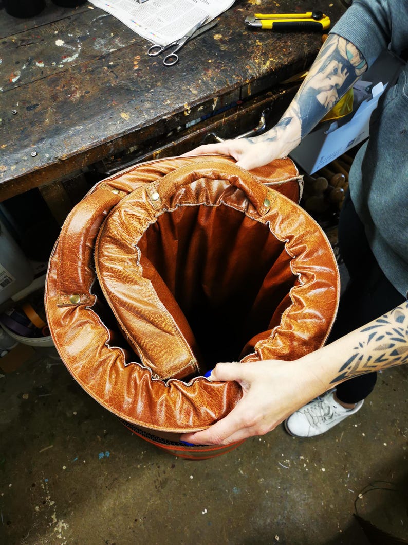 Handmade buffalo leather gym mat being rolled up by hand, illustrating its flexibility and practicality. The piece can easily be stored or moved, making it perfect for dynamic interiors or home gym spaces that value both beauty and function.