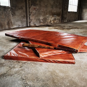 Close-up of the thick hand-sewn edges on the full-grain buffalo leather gym mat. Each seam shows artisanal precision, giving this large leather rug a unique, durable aesthetic ideal for high-end home decor and handcrafted interiors.
