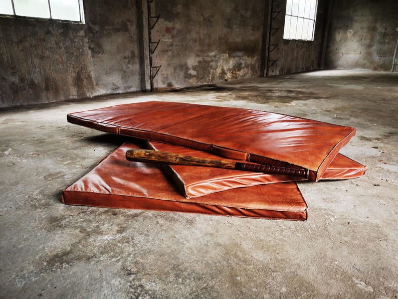 Close-up of the thick hand-sewn edges on the full-grain buffalo leather gym mat. Each seam shows artisanal precision, giving this large leather rug a unique, durable aesthetic ideal for high-end home decor and handcrafted interiors.