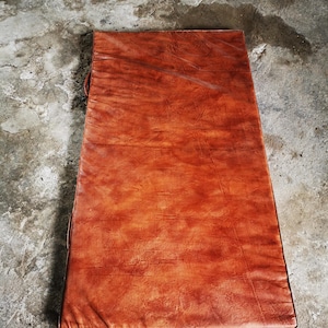 Top-down view of the large buffalo leather floor mat showcasing its uniform tone and natural patina. The minimal and elegant design blends craftsmanship with function, ideal for decorating a home gym, reading area, or minimalist interior.
