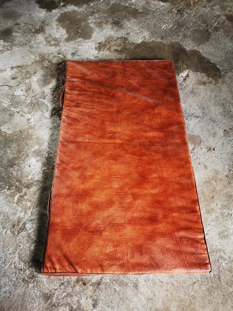 Top-down view of the large buffalo leather floor mat showcasing its uniform tone and natural patina. The minimal and elegant design blends craftsmanship with function, ideal for decorating a home gym, reading area, or minimalist interior.