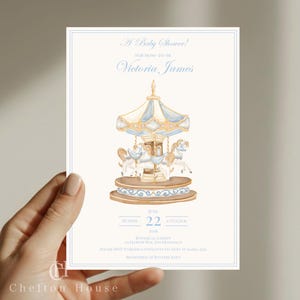 Könnte beinhalten: Babyparty-Einladung mit einem Karussell-Design in zarten Blau- und Cremetönen. Die Einladung enthält den Text "A Baby Shower!" und Details für Victoria James, mit dem Datum 22. Juni 2036 und dem Veranstaltungsort.