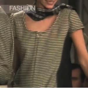 May include: A short-sleeved, striped shirt with a scoop neck. The shirt has horizontal stripes in shades of gray and white. The word "FASHION" is visible in the upper left corner. The shirt is part of a fashion collection.