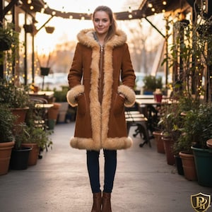 Może przedstawiać: Długi brązowy płaszcz z kapturem i futrzanym wykończeniem. Płaszcz ma zapięcie na zamek błyskawiczny i kieszenie. Futrzane wykończenie jest w jaśniejszym odcieniu brązu. Płaszcz jest do kolan.