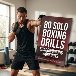 Puede incluir: Un hombre con camiseta sin mangas y pantalones cortos negros practica boxeo en la sombra, sosteniendo un libro titulado "80 Solo Boxing Drills Shadowboxing Workouts". El libro es un cuaderno de trabajo PDF para entrenamiento en casa sin equipo. El fondo incluye una ventana y equipo de ejercicio.