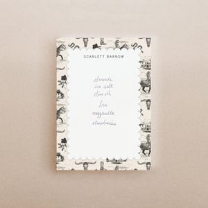 May include: A rectangular notepad with a scalloped white center and a beige border featuring a black and white western pattern of horses, skulls, and boots. The text SCARLETT BARROW is printed at the top, followed by a handwritten grocery list.