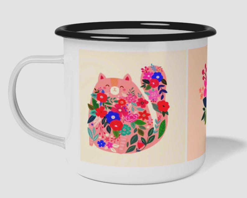 K&ouml;nnte beinhalten: Ein wei&szlig;er Emaillebecher mit schwarzem Rand und Henkel, der eine grafische Illustration einer rosa Katze zeigt, die mit leuchtend roten, blauen und rosa Blumen sowie gr&uuml;nen Bl&auml;ttern auf cremefarbenem Grund bedeckt ist, mit einem Teilmotiv an der Seite.