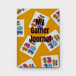 May include: A hardcover journal with a mustard yellow background. The cover features scattered white rectangles with colorful video game controllers and the text "My Gamer Journal". The journal is designed for gamers.