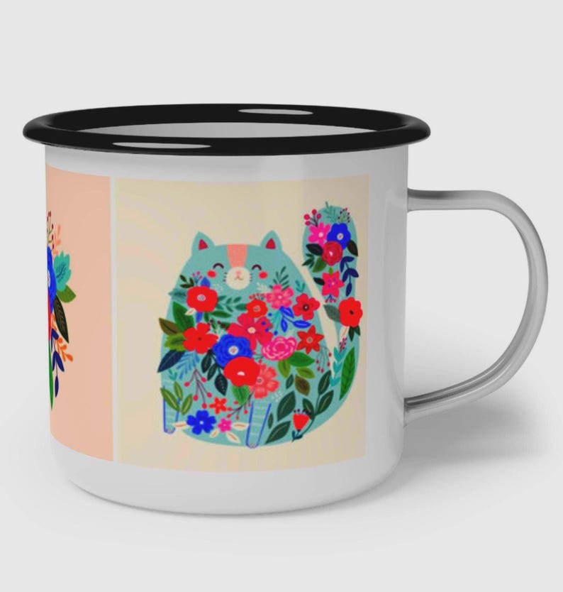 K&ouml;nnte beinhalten: Ein wei&szlig;er Emaillebecher mit schwarzem Rand und silbernem Henkel. Der Becher zeigt eine grafische Illustration einer hellblauen Katze, die mit leuchtend roten, rosa und blauen Blumen bedeckt ist, neben einem Blumenarrangement auf pfirsichfarbenem Grund.